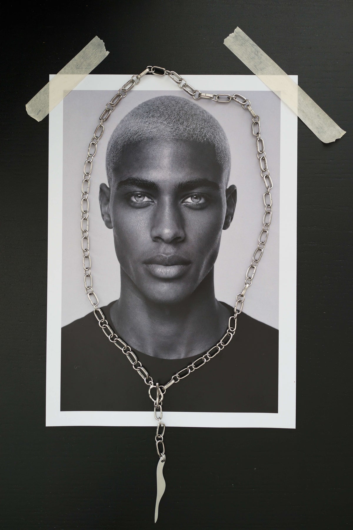 SARAH BOUNAB “Abyssal Flame” necklace in stainless steel with a polished aluminum flame pendant, handmade in Switzerland.