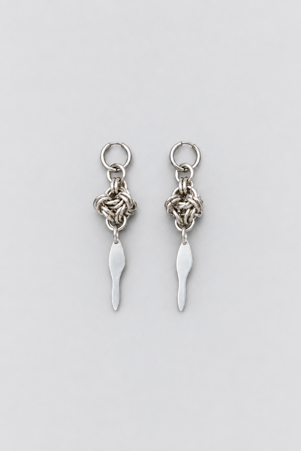 SARAH BOUNAB Knot Blade Earrings with stainless steel knots and long aluminum blades.
