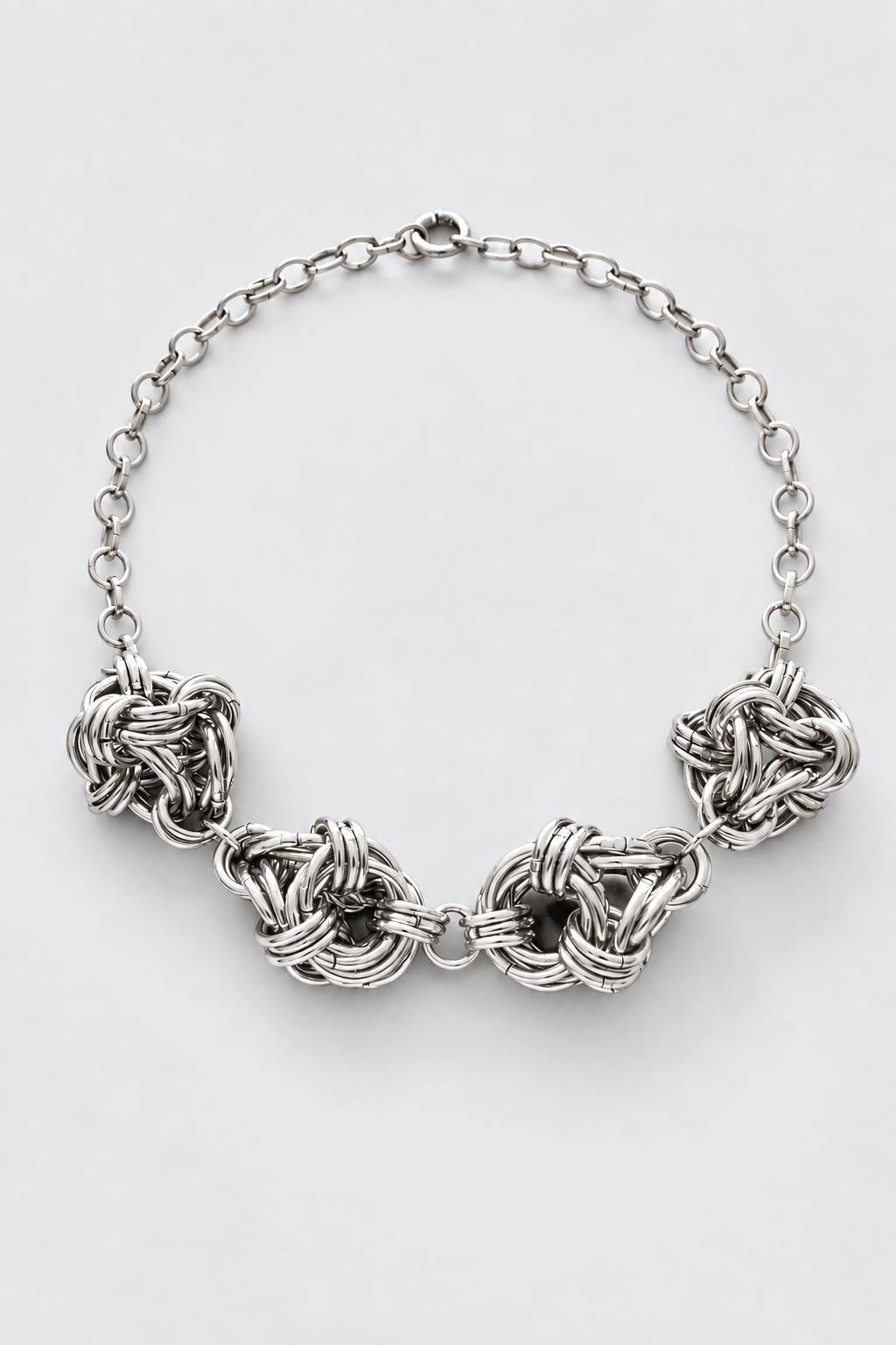 SARAH BOUNAB Quadrivium Knot Necklace with four sculptural stainless steel knots, handmade in Switzerland.