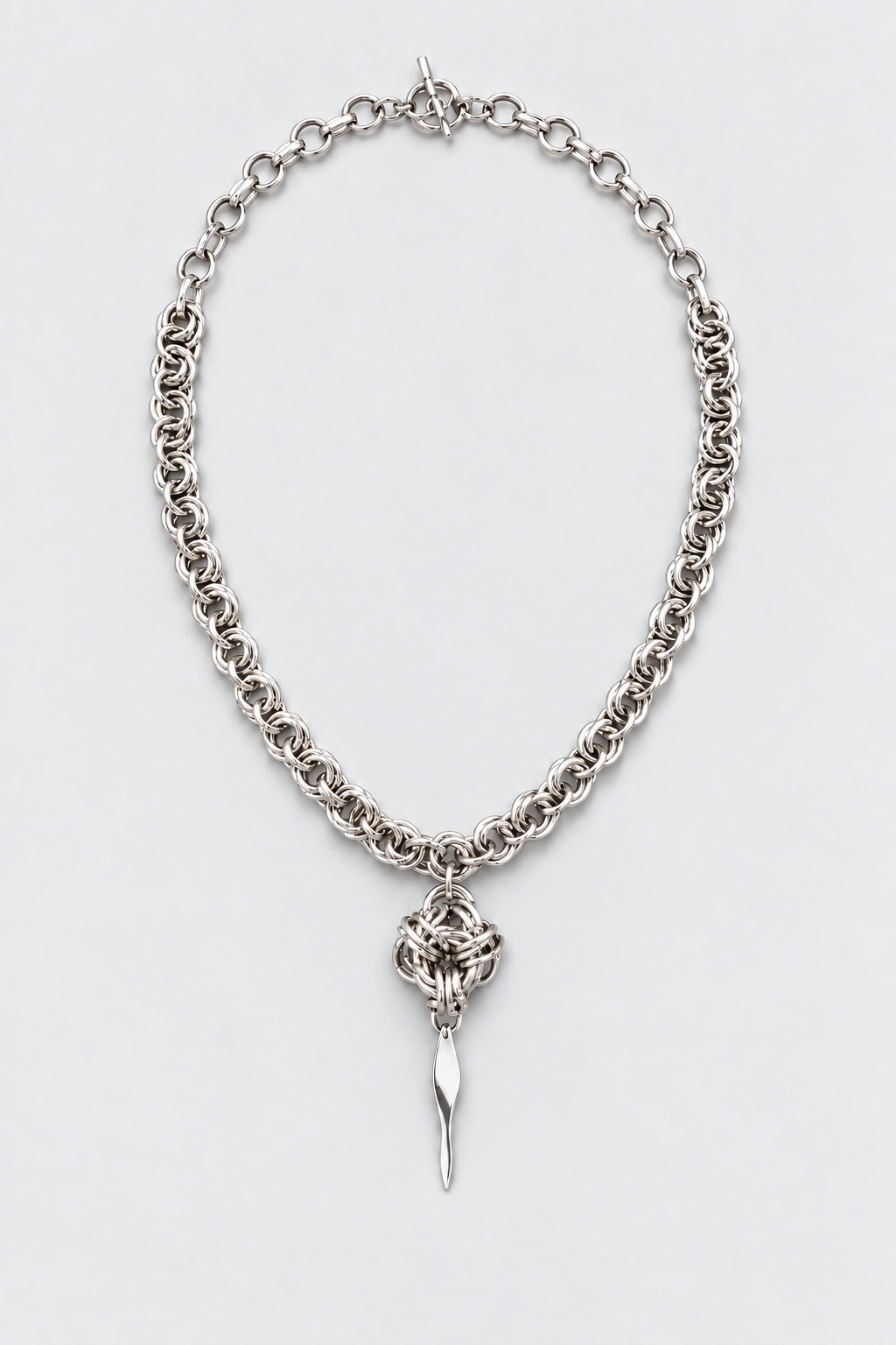 SARAH BOUNAB “Rift Talisman” necklace made of stainless steel mesh with a twisted pendant in mirror-polished aluminum.